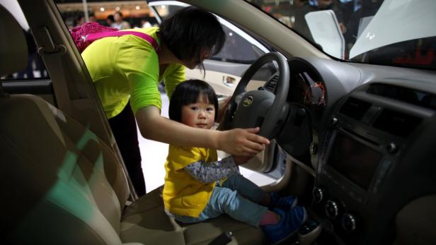 A girl sits inside a BYD car during the 15th Shanghai International Automobile Industry Exhibition in Shanghai April 21, 2013. BYD Co, one of the better known Chinese brands thanks to a stake held by billionaire U.S. investor Warren Buffett, may stop making conventional gasoline-fuelled cars within two years and focus on &#039;new energy&#039; battery models as part of a &quot;re-birth plan&quot; to arrest a slump in sales. REUTERS/Carlos Barria (CHINA - Tags: BUSINESS TRANSPORT)