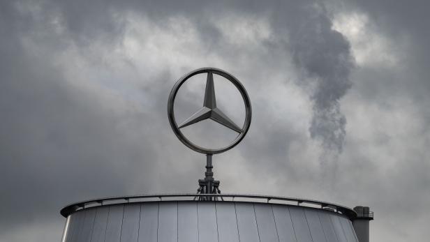 Mercedes-Stern auf einem Werksgebäude, dunkle Wolken ziehen dahinter auf